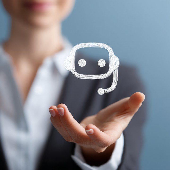 Businesswoman holding a floating chatbot icon, symbolizing artificial intelligence in customer service and digital transformation.