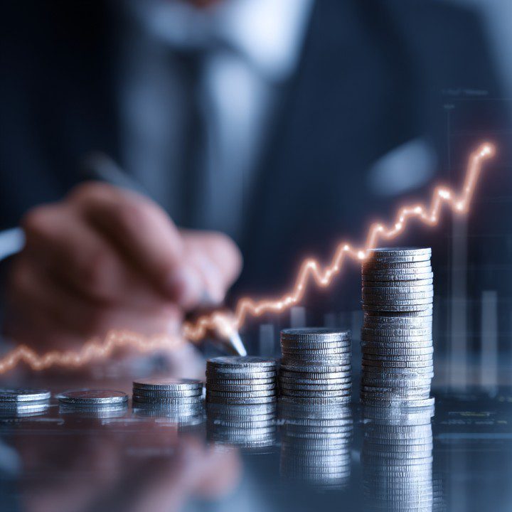 Stacked silver coins with glowing rising line chart illustrating financial growth and investment performance in a business setting.