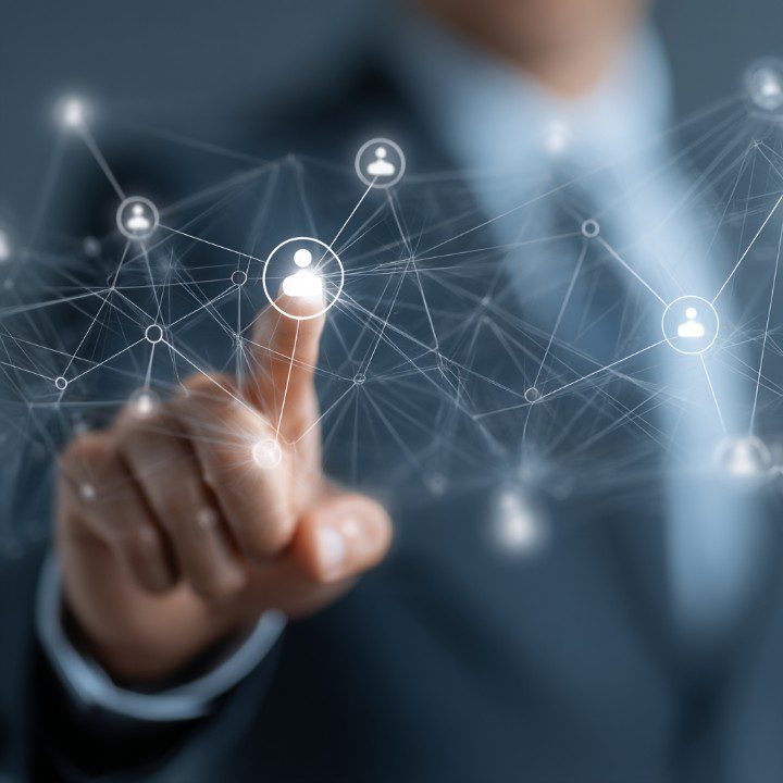 Close-up of a businessperson's finger touching a digital network interface with human icons, symbolizing HR and workforce management.