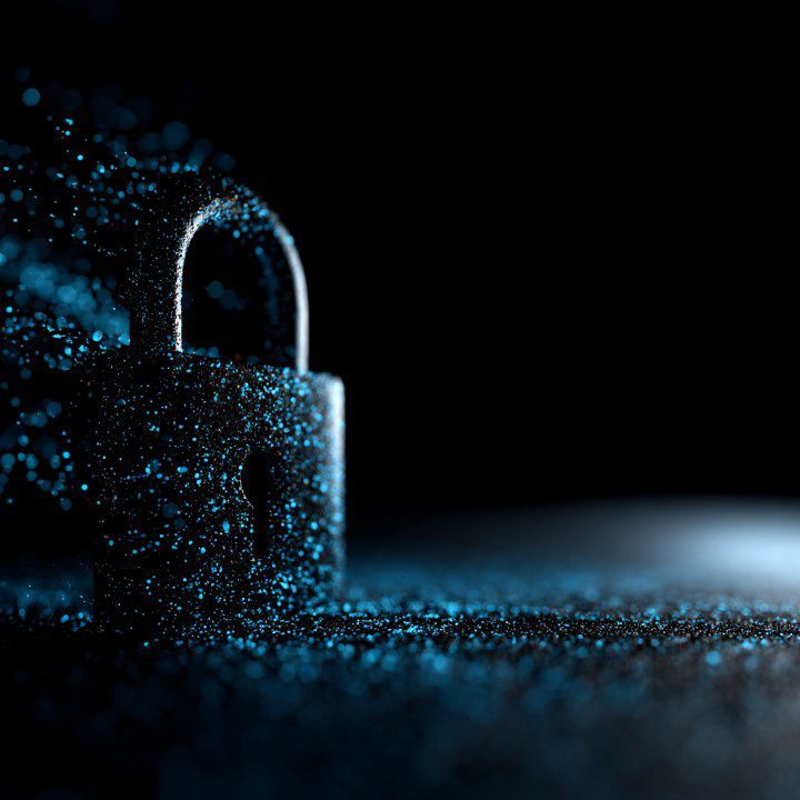A glowing digital lock made of blue particles on a dark background representing cybersecurity and data protection.